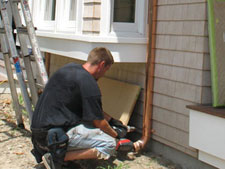 wall brackets securing downspout to the sidewall